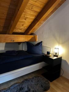 een bed met blauwe kussens en een bureau in een kamer bij Wohnung im Herzen von Immenstadt im Allgäu in Immenstadt im Allgäu