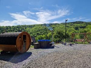 uma cabana de madeira com uma mesa de piquenique e um parque infantil em Domki Na Grapie em Międzybrodzie Bialskie