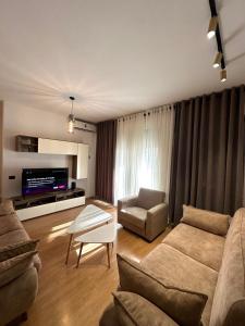 ein Wohnzimmer mit einem Sofa und einem TV in der Unterkunft Lake Escape - Home 2 in Tirana