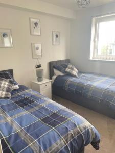 1 dormitorio con 2 camas y ventana en THE PAISLEY PENTHOUSE - ABBEY VIEW, en Paisley