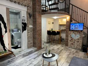a living room with a staircase and a brick wall at Apartment Tena in Senj