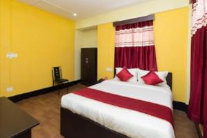 a bedroom with a bed with red and yellow walls at Stay Inn Pumpkin Guest House in Shillong