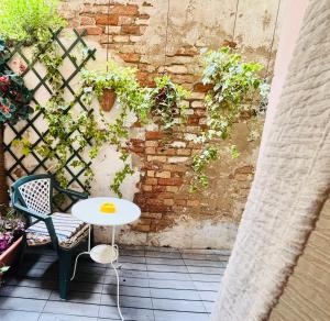 a table and chairs on a patio with a brick wall at Dorsoduro House in Venice