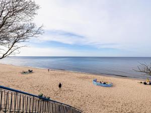 people on a beach with boats on the sand at Apartment in Pobierowo near Baltic Beach in Pobierowo