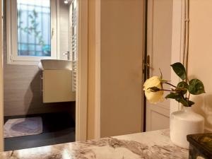 eine Vase mit einer Blume auf der Theke im Bad in der Unterkunft Dorsoduro House in Venedig