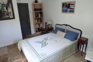 ein Schlafzimmer mit einem Bett mit blauen Kissen in der Unterkunft Maison en Drôme provençale in Eygaliers