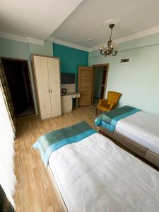 a hotel room with two beds and a desk at Kars Center Hotel in Kars