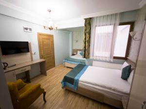 ein Hotelzimmer mit zwei Betten und einem Schreibtisch in der Unterkunft Kars Center Hotel in Kars