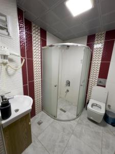 y baño con ducha, aseo y lavamanos. en Kars Center Hotel, en Kars