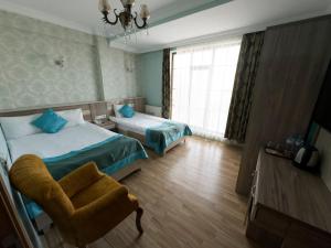 Un pat sau paturi într-o cameră la Kars Center Hotel