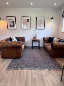 dois sofás de couro castanho numa sala de estar em The Little Thatch - Close to Marlow and Henley em Marlow
