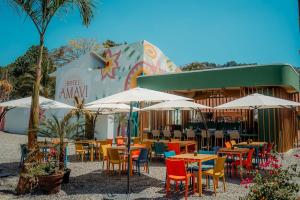 an outdoor restaurant with tables and chairs and umbrellas at Hotel Amavi in Jacó