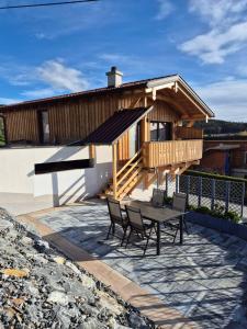 una casa con un tavolo e sedie di fronte di Fernblick Chalet Gruber a Grafendorf bei Hartberg