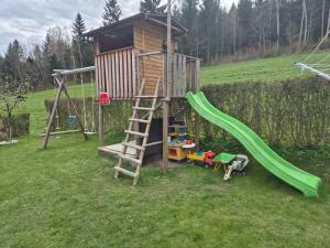 un parco giochi con scivolo e una casetta per i giochi di Fernblick Chalet Gruber a Grafendorf bei Hartberg