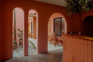 una sala de estar con paredes y arcos de color naranja en Hotel Amavi, en Jacó