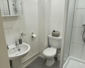 La salle de bains blanche est pourvue de toilettes et d'un lavabo. dans l'établissement For Students Only Private Rooms with Shared Bathroom at Queens Court in Leicester, à Leicester