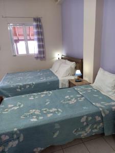 AkhladheríにあるKorasida Blue Coastのベッドルーム1室(ベッド2台、窓付)