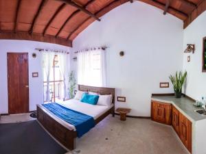 a bedroom with a bed and a large window at Gypsy Garden Guesthouse & Homestay in Kosgoda