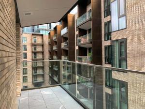 een balkon met glazen leuningen en een bakstenen gebouw bij Luxury City Retreat - 1 Bed Fully Equipped in Londen