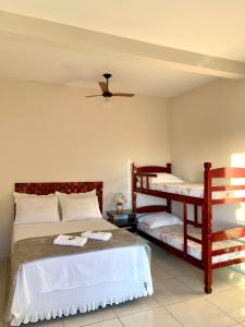 a bedroom with two beds and a bunk bed at Pousada Aconchego De São Thomé in São Thomé das Letras