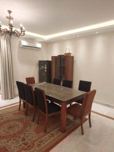 una sala da pranzo con tavolo e sedie in legno di 2bedroom Apartment and compond Al Khamail a Sheikh Zayed