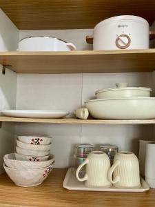 a shelf filled with white dishes and utensils at Condo near Airport in Lapu Lapu City +4 photos