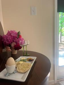 a table with a plate of food and a glass of wine at Cottage style home close to golfing and lake 