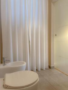 a white bathroom with a toilet and a sink at Casa per vacanze Mevania in Bevagna