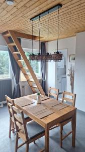 une table en bois avec deux chaises et un lustre dans l'établissement Haus Westharz Hahnenklee, à Laubhütte