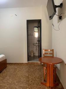 a room with a table and a television and a bathroom at Hotel sueño Tropical in Tarapoto