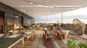 a rooftop patio with tables and chairs and lights at Hilton Garden Inn Debrecen City Centre in Debrecen