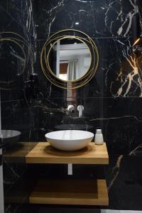 een badkamer met een witte wastafel en een spiegel bij Incanto Luxury Suites in Nafpaktos