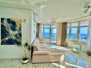 a living room with a couch and a painting at Direct sea view in Odesa