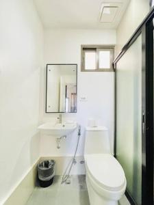 a white bathroom with a toilet and a sink at WV 8 Serene Family Room in Iloilo City