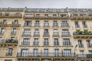 a large building with windows and balconies at Appartement de charme de 60 m2 entre Montmartre et Batignolles in Paris