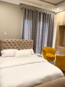 een slaapkamer met 2 bedden en een gele stoel bij Sweet home apartment in Namulanda