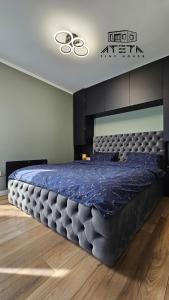 een slaapkamer met een groot bed en een blauw dekbed bij ATETA Tiny House 