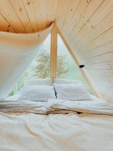 Ce lit se trouve dans un dortoir doté d'une grande fenêtre. dans l'établissement A-frame Forest Nest, à Cerklje na Gorenjskem