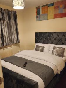 a bedroom with a large bed with a black headboard at Captivating 3-Bed House in Kent in Kent