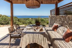 einen Esstisch auf einer Terrasse mit Meerblick in der Unterkunft Montesea - Luxury Nature Villas in Vasilikos