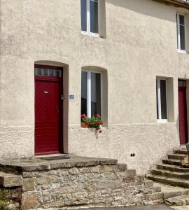 appartement L'Atelier in Isches في Isches: باب احمر على جانب المبنى