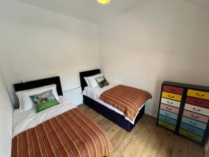 a bedroom with two beds and a dresser at Alpaca farm 3 bed farmhouse THE ALPACA PLACE in Dromara