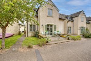 a house with a wooden deck in front of it at Toad Hall Pet-Friendly Family Stay, Lake Access in Somerford Keynes