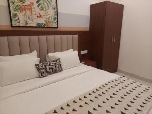 Un dormitorio con una gran cama blanca con dos almohadas. en Aster service Apartments, en Bangalore