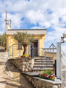 una casa amarilla con un árbol y algunas flores en Regina Vittoria Relais en Vico Equense