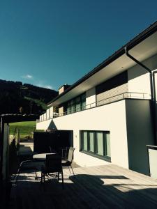 Un edificio con sillas y una mesa en una terraza. en TownVille, en Flachau