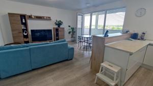 sala de estar con sofá azul y cocina en Apartmán Martina, en Trebišov