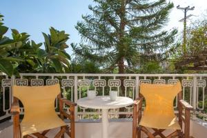 einen weißen Tisch und zwei Stühle auf dem Balkon in der Unterkunft CALYPSO in Elafonisos