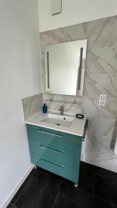 a bathroom with a blue sink and a mirror at Chambre idéale séjour randonnée ou professionnel in Gex