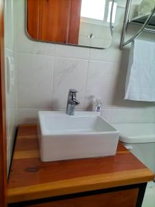 a white sink on a wooden counter in a bathroom at KC Hotel & Suites in Comitán